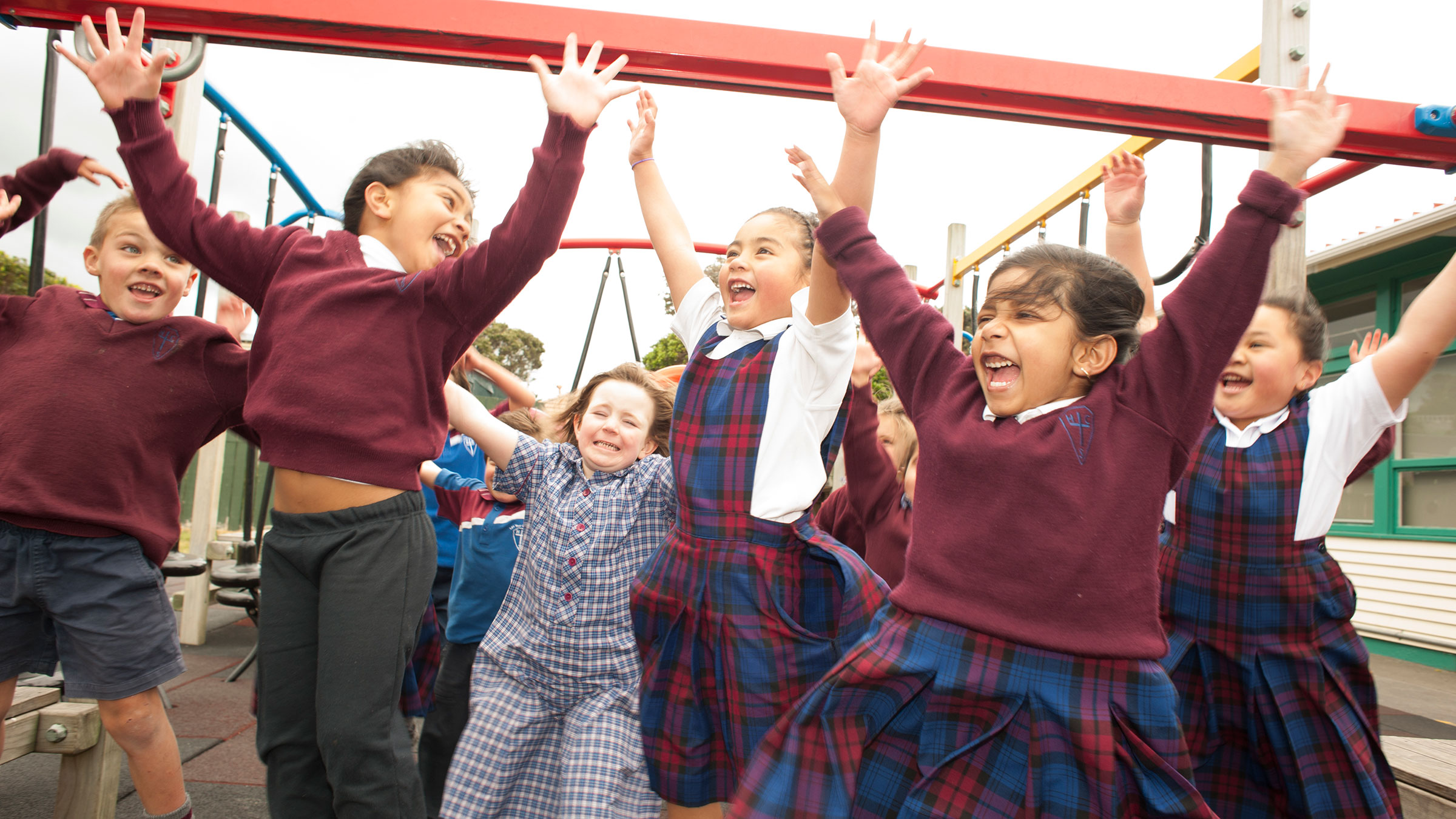 A group of students jumps, smiling and cheering