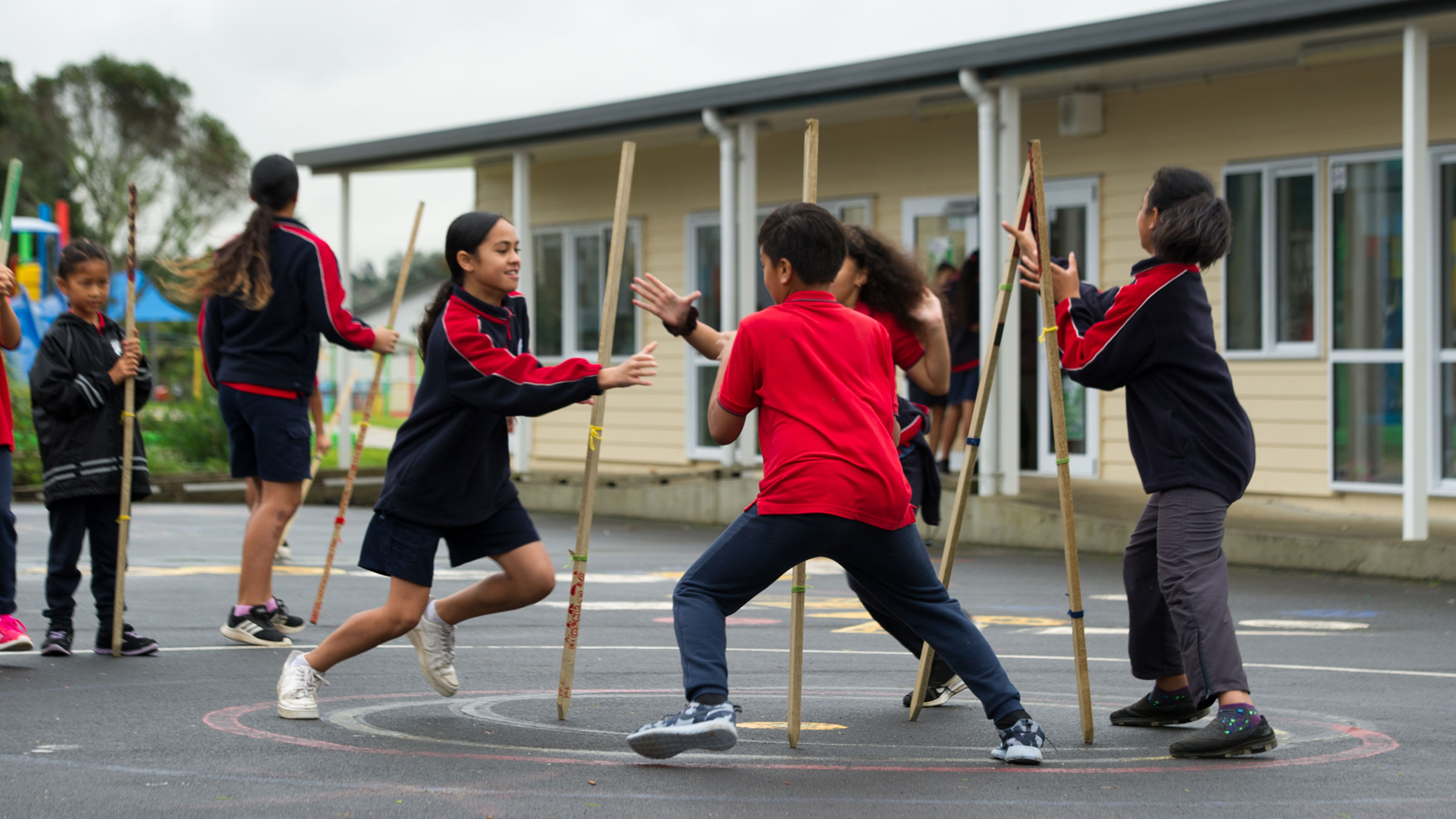 Students playing a game with rākau.