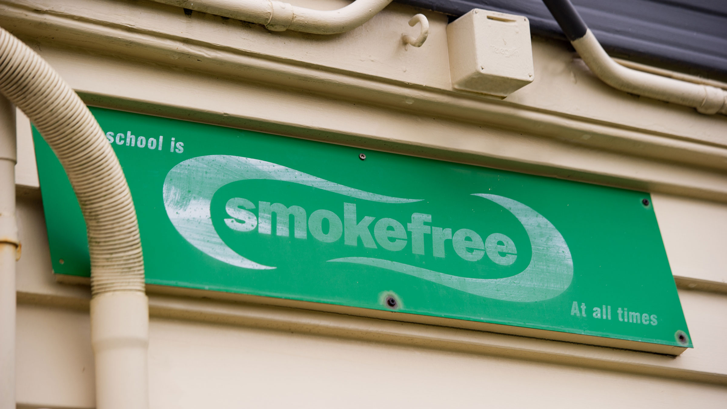 Faded smokefree sign on school building