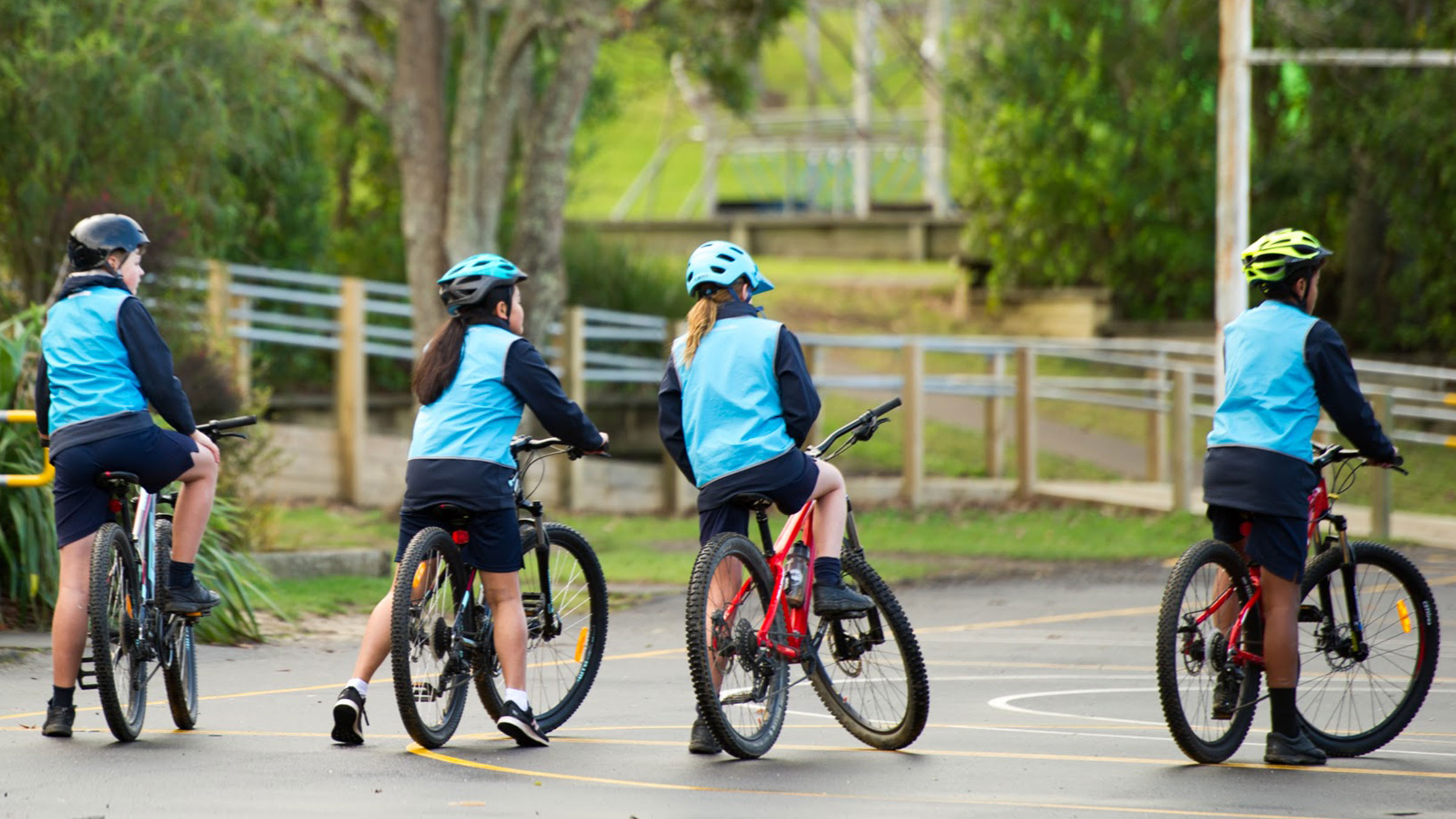 A group of four students riding their bikes