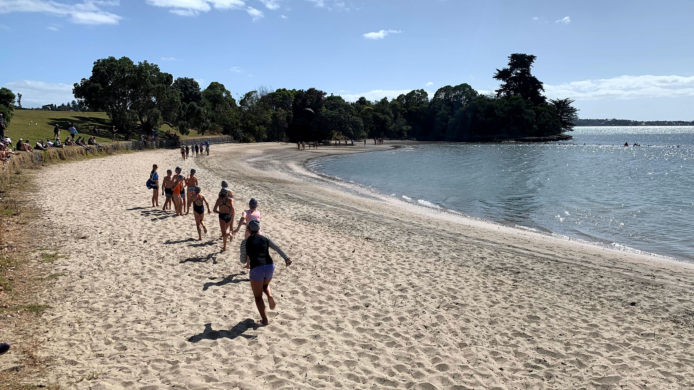 A group of students running down a beach